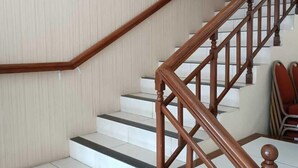 A staircase with wooden railings and white tiled steps.