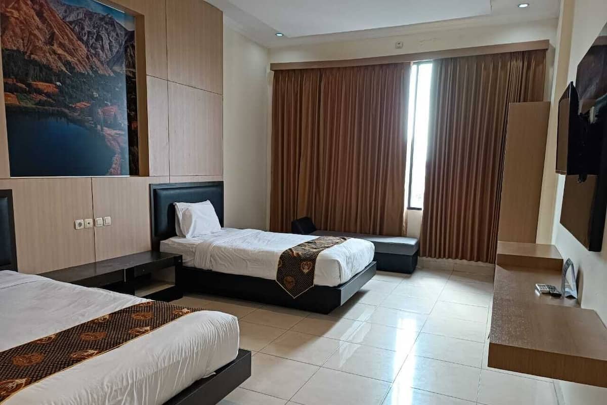 A hotel room with two beds, a large painting of a mountain landscape, a TV, and a window with curtains.
