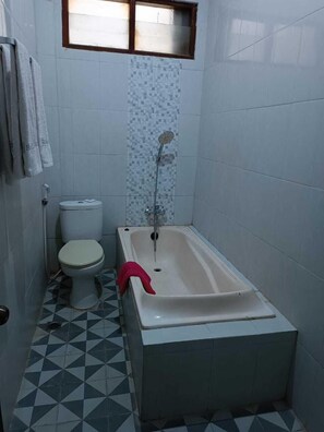 Ein kleines Badezimmer mit Toilette, Dusche und Badewanne.