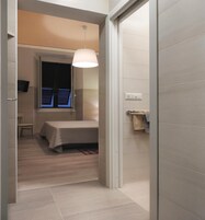 Una camera da letto moderna con un letto, un comodino e una lampada a sospensione.