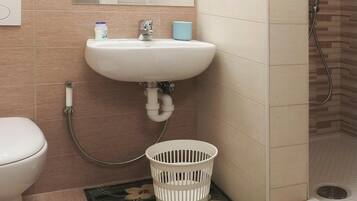 A bathroom with a sink, toilet, and shower.