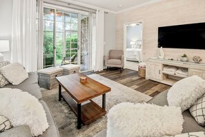 Relax in a serene space with a balcony view, comfortable seating, and a warm ambiance.