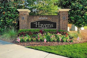 Welcome to The Havens, where a beautifully maintained flower bed and tidy lawn greet guests at the entrance.