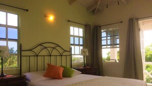 A bedroom with a bed, nightstands, a lamp, and windows with curtains. - Sugar Fields Hoilday Home with Private Pool. (Valley Church)