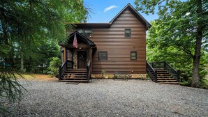 A wooden cabin with a porch, steps, and a flag. - Drink Up The View - Morganton (Morganton)