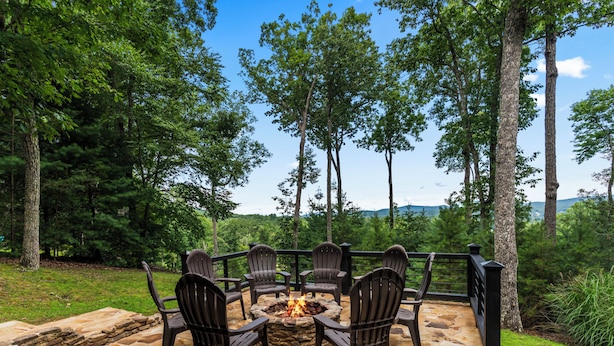 An outdoor seating area with stone flooring and Adirondack chairs around a fire pit. - Drink Up The View - Morganton (Morganton)