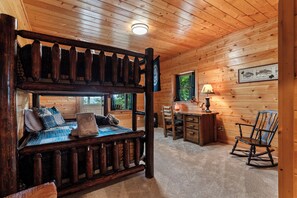 A cabin interior with a bunk bed, desk, rocking chair, and a window with a view of trees. - Drink Up The View - Morganton (Morganton)