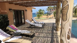 A sunlit outdoor lounge area with lounge chairs and a pool. - McGann Estate Resort: Two Houses on the Beach, sleeps 14 (Los Barriles)