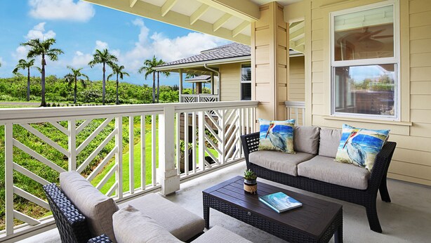 A covered outdoor seating area with a view of a lush green landscape and palm trees. - Pili Mai 3B: Luxury Condo w/hot tub & pool, near beaches, golf & dining! (Koloa)
