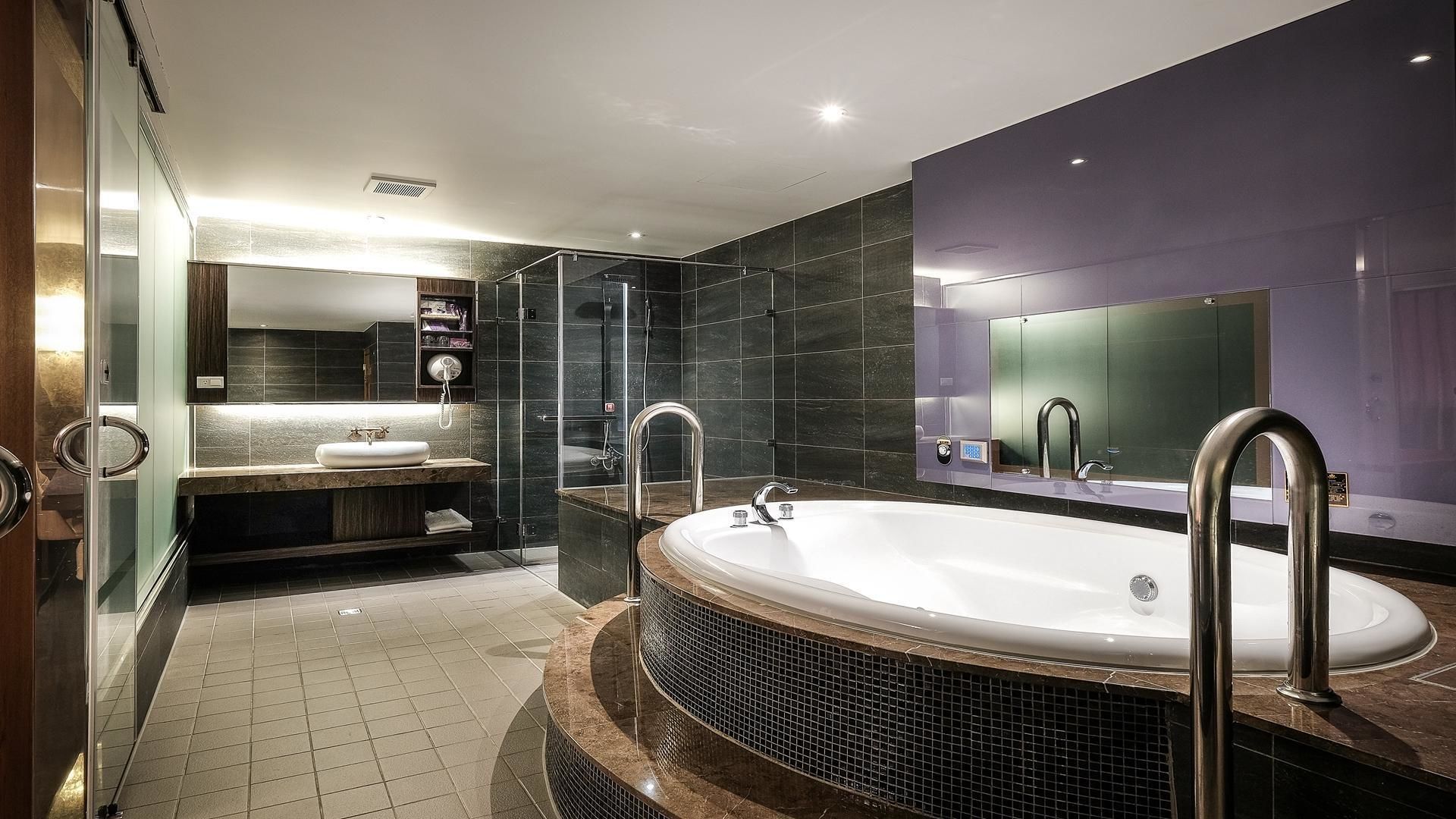 A modern bathroom with a freestanding bathtub, a glass-enclosed shower, and a vanity with a mirror.