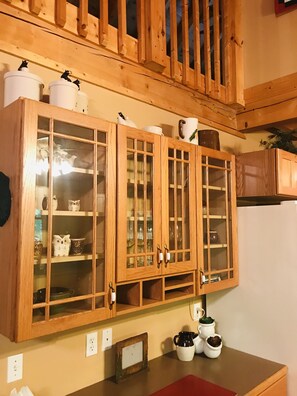 Kitchen essentials and decorative items are stored in this wall-mounted cabinet.