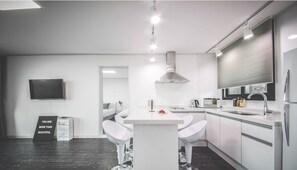 Suíte, 2 quartos | Cozinha americana privada | Geladeira, micro-ondas, cooktop, chaleira elétrica