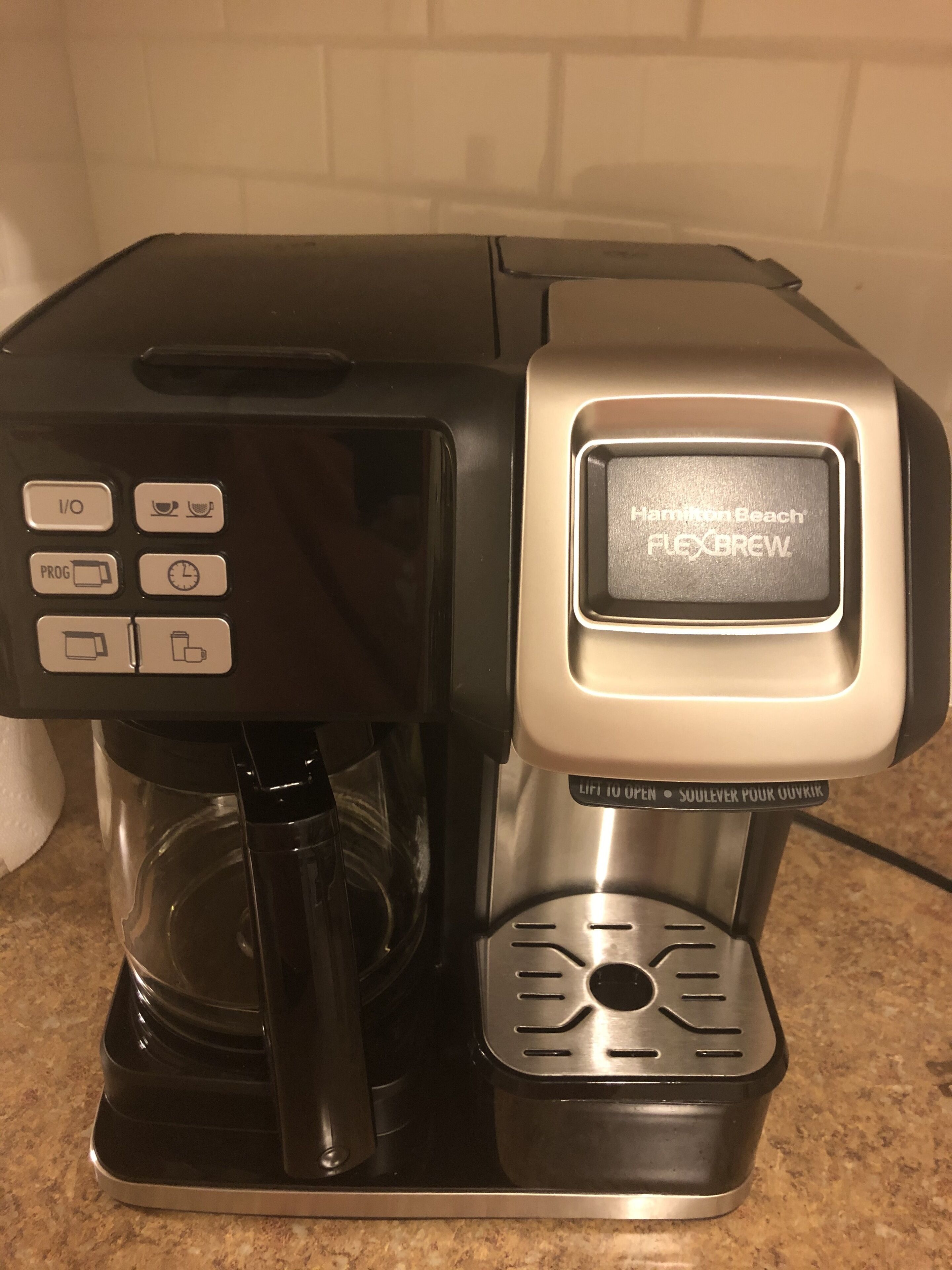 A coffee maker with a digital display, control panel, and a water reservoir.