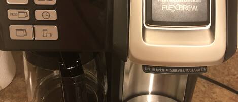A coffee maker with a digital display, control panel, and a water reservoir.