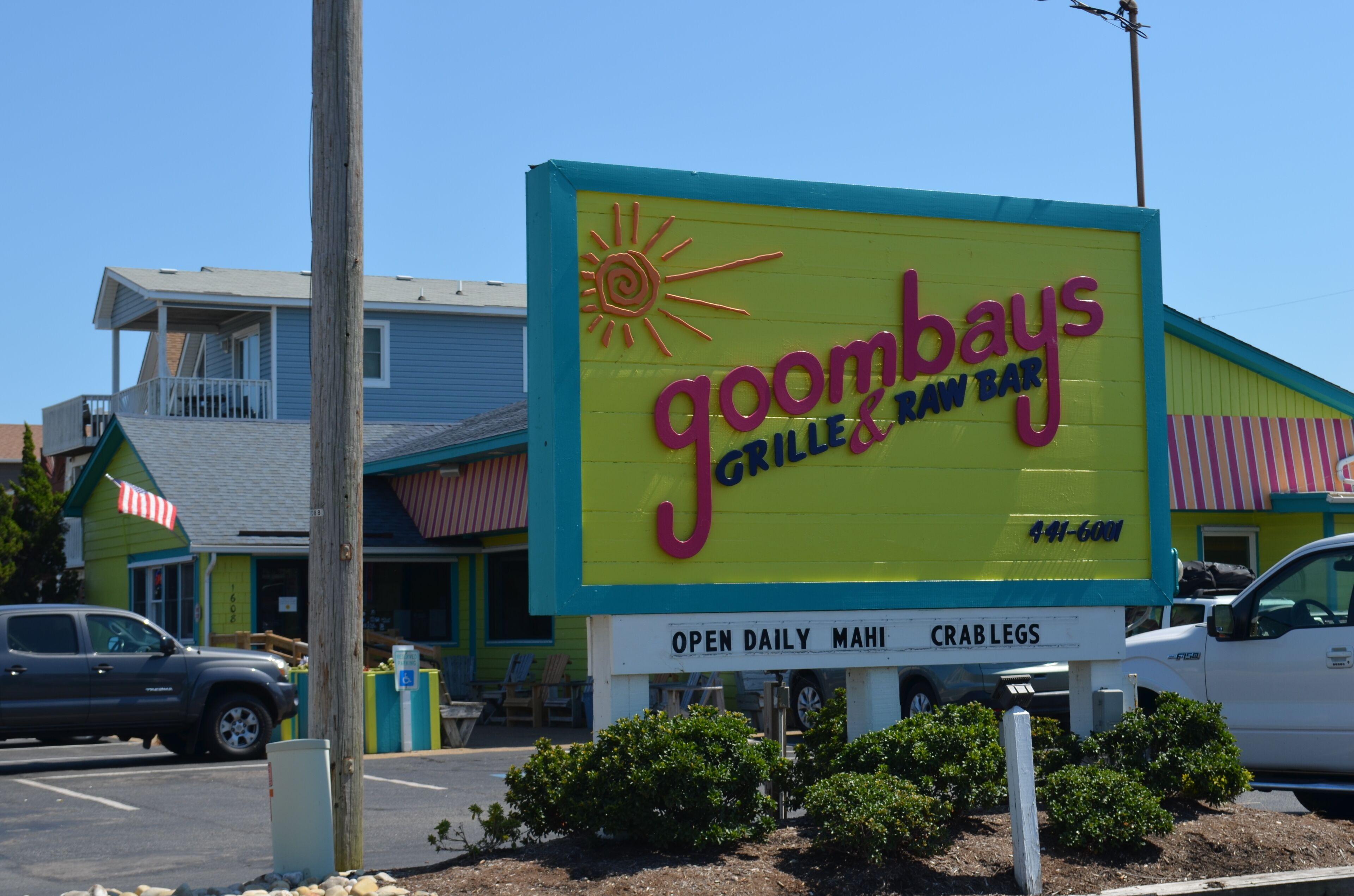Placa de restaurante para Goombays Grilled & Raw Bar com um sol estilizado.