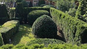 A house with a well-maintained garden featuring neatly trimmed hedges and a lawn. - Cripple Cove Apartment in historic home across from harbour in Gloucester, MA (Gloucester)