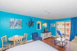 Relax in this stylish room with a comfortable bed, round table, and blue armchair.
