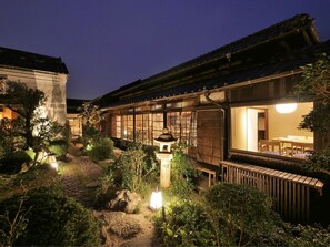 A traditional Japanese ryokan with tatami mat rooms, a wooden exterior, and a garden with a lantern path. - Hotel Cultia Dazaifu (Dazaifu)