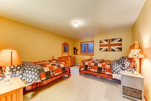Ein Schlafzimmer mit zwei Betten, einem Schminktisch, einem Fenster und einer Wand mit einer Union Jack Flagge.