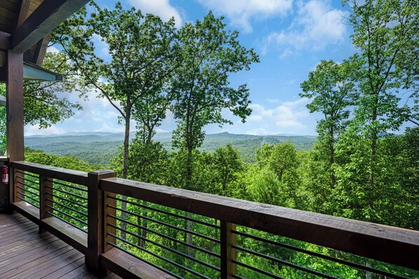 A wooden deck with a railing overlooking a forested landscape with distant mountains. - New Heights - Blue Ridge GA (Blue Ridge)