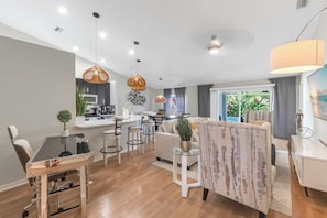 A modern living room with a dining area, kitchen, and a large window with a view. - Florida Paradise Home Near IMG Academy & Siesta Key Beach (Bradenton)