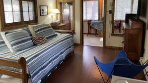Een gezellige kamer met een bed, bureau, stoel en een eethoek.