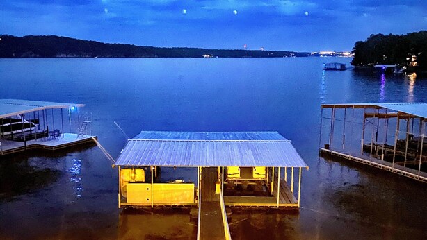 Una proprietà sul lungomare con un pontile in legno, una zona coperta e una piscina.