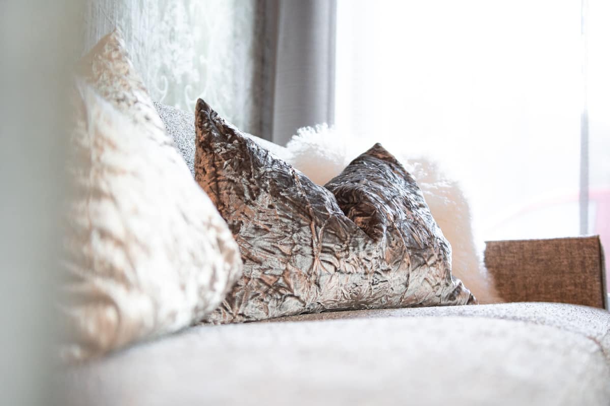 A sofa with patterned cushions and a fluffy throw blanket.