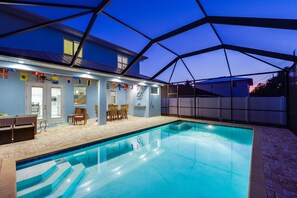 A swimming pool with a covered patio area, a dining table, and chairs. - SEASONAL RENTAL - Spacious Private Pool Home - WALK TO BEACH & MERCATO (Naples)