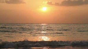 A sunset over the ocean with waves approaching the shore. - SEASONAL RENTAL - Spacious Private Pool Home - WALK TO BEACH & MERCATO (Naples)