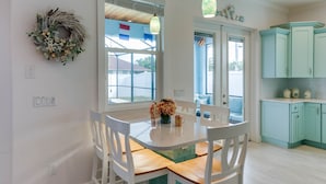 A kitchen with white cabinets, a dining table with chairs, and a window with a view of the outside. - SEASONAL RENTAL - Spacious Private Pool Home - WALK TO BEACH & MERCATO (Naples)