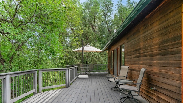 A wooden deck with a table and chairs, surrounded by trees. - Pickle Ball Courts, Peaceful Deck Next to Creek! (Durango)