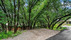 A gravel path leading through a wooded area with trees and a fence. - Pickle Ball Courts, Peaceful Deck Next to Creek! (Durango)