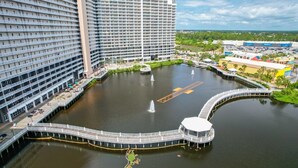 A high-rise hotel with a waterfront promenade, a central fountain, and a dock area. -   Family Friendly 2Bedroom +Bunks, High Chair,Crib,Beach Chairs,Towels and Games (Panama City Beach)
