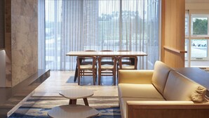 A modern hotel room with a dining area, a sofa, and a coffee table. - Fairfield Inn & Suites by Marriott Vero Beach (Vero Beach)