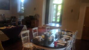 A dining area with a round table, white chairs, and a coffee machine. - The Prospect Room -  HSI (Idaho Falls)