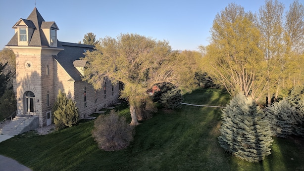 A stone building with a tower and a staircase leading to the entrance. - The Prospect Room -  HSI (Idaho Falls)