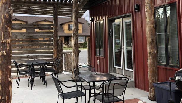 Un patio couvert avec des meubles d’extérieur et un barbecue.