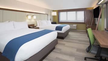 Una habitación de hotel con dos camas, un escritorio, una silla y un televisor.