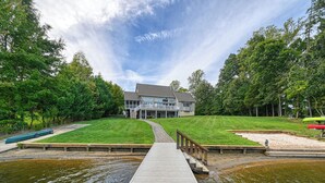 A lakeside property with a wooden dock leading to a house with a covered porch. - Resort-like LAKEFRONT 5br/4ba home & boathouse in quiet cove. Fun 4 all ages! (Bumpass)