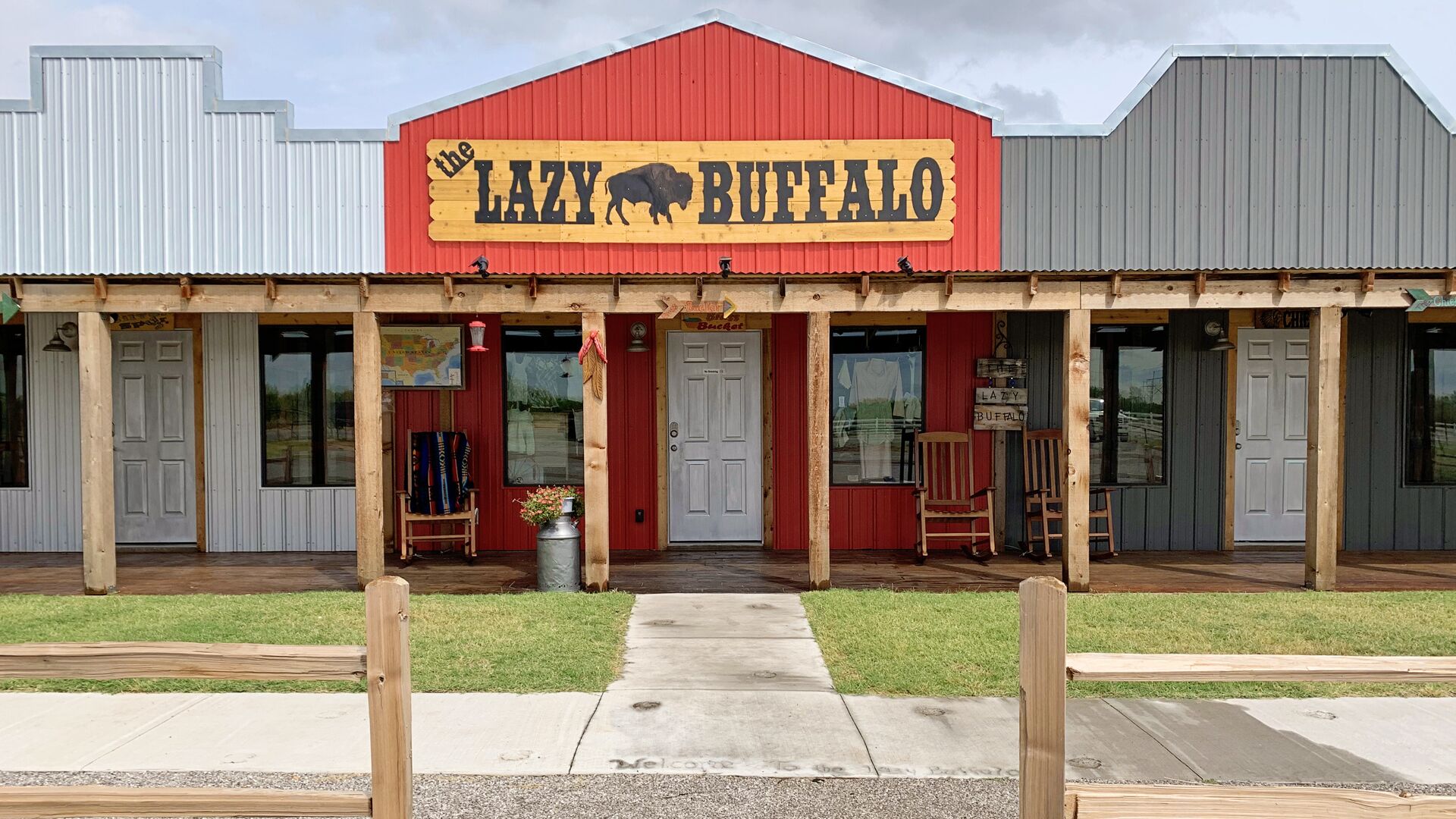 En bygning med en rød facade og et skilt med teksten "LAZY BUFFALO".