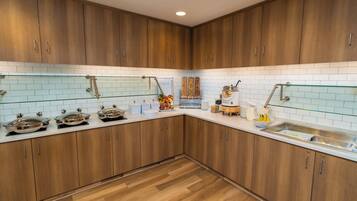 Una cocina moderna con armarios de madera, salpicadero de azulejos blancos y electrodomésticos de acero inoxidable.