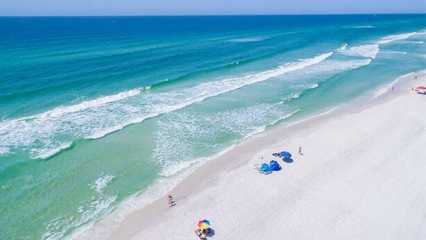 A beach with clear turquoise water, white sand, and umbrellas. - Golf Cart! Walk to the Pool & Beach! 3 Kings! 8 Bikes! Tons of Fun! Stay Awhile at NatureWalk on 30A (Santa Rosa Beach)