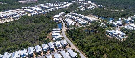 An aerial view of a residential area with multiple buildings, roads, and a lake.