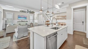 A spacious kitchen with a central island, stainless steel appliances, pendant lighting, and a view to the living area. - Golf Cart! Walk to the Pool & Beach! 3 Kings! 8 Bikes! Tons of Fun! Stay Awhile at NatureWalk on 30A (Santa Rosa Beach)
