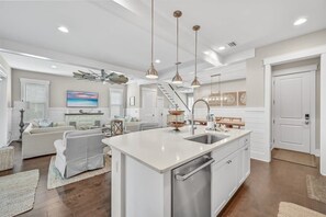 A spacious kitchen with a central island, stainless steel appliances, pendant lighting, and a view to the living area. - Golf Cart! Walk to the Pool & Beach! 3 Kings! 8 Bikes! Tons of Fun! Stay Awhile at NatureWalk on 30A (Santa Rosa Beach)
