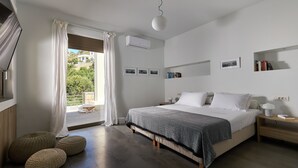 Een slaapkamer met een bed, nachtkastjes, een raam met gordijnen en uitzicht op groen.