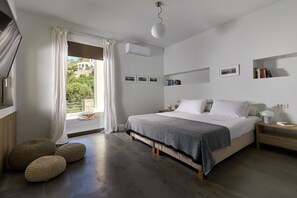 Een slaapkamer met een bed, nachtkastjes, een raam met gordijnen en uitzicht op groen.