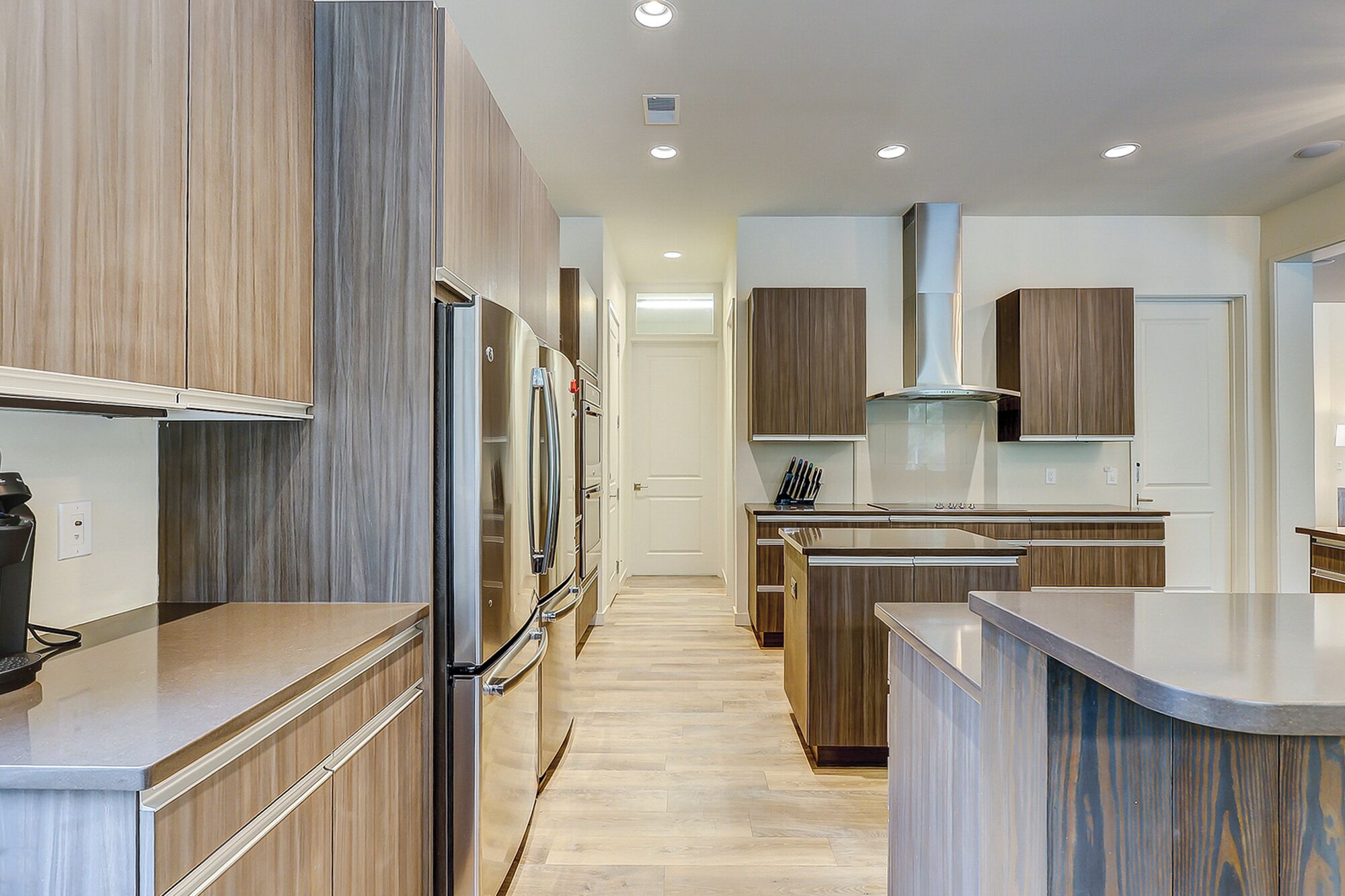 A modern kitchen with wooden cabinetry, stainless steel appliances, and a central island.