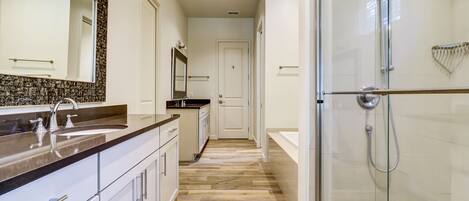 A modern bathroom with a glass shower enclosure, a double sink vanity, and a walk-in shower.
